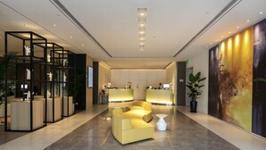 A modern lobby with a reception desk, seating area, and a large wall mural. - JinJiang Metropolo Hua Ting Guest House (Shanghai)