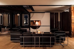 A modern living room with a fireplace, leather sofas, and a minimalist design. - Hotel Boite (Borca di Cadore)