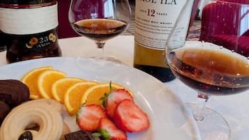 A dining table with a plate of food, a bottle of Caol Ila whisky, and a glass of wine.