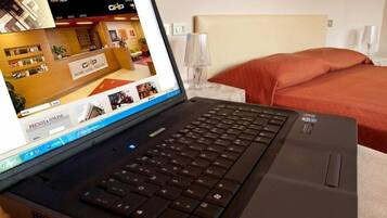 En bærbar computer på en seng, der viser et hotels websted.