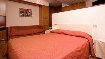 A hotel room with two beds, a painting on the wall, and a wooden headboard.