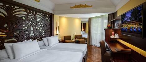 A hotel room with two beds, a desk, a TV, and a decorative wall.