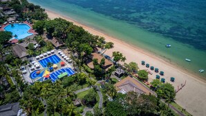 An aerial view of a resort with a swimming pool, beach, and clear blue waters. - Prama Sanur Beach Bali (Denpasar)
