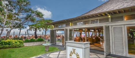 An Italian Pavilion & Bar with outdoor seating and a view of the ocean.