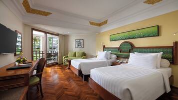 A hotel room with two beds, a desk, a chair, and a large window.