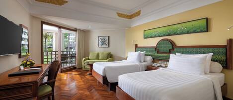 Une chambre d’hôtel avec deux lits, un bureau, une chaise et une grande fenêtre.