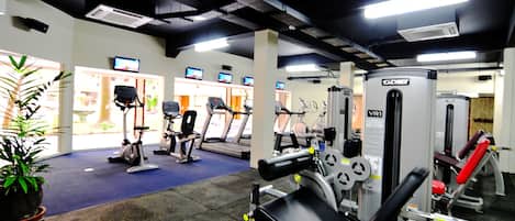 A gym with treadmills, stationary bikes, and weight machines.