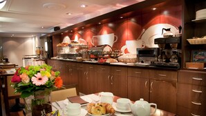 A breakfast buffet with a variety of food items, including pastries, fruits, and beverages.