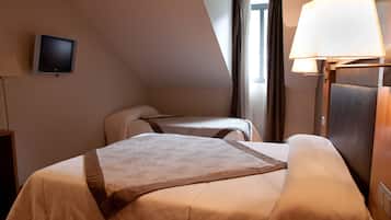 Una habitación de hotel con dos camas, televisión, lámpara y ventana con cortinas.