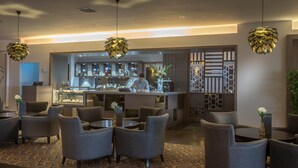 Een modern restaurant met een bar, zitplaatsen en een kok die gerechten bereidt.