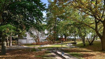 Un parque con senderos, bancos y árboles.