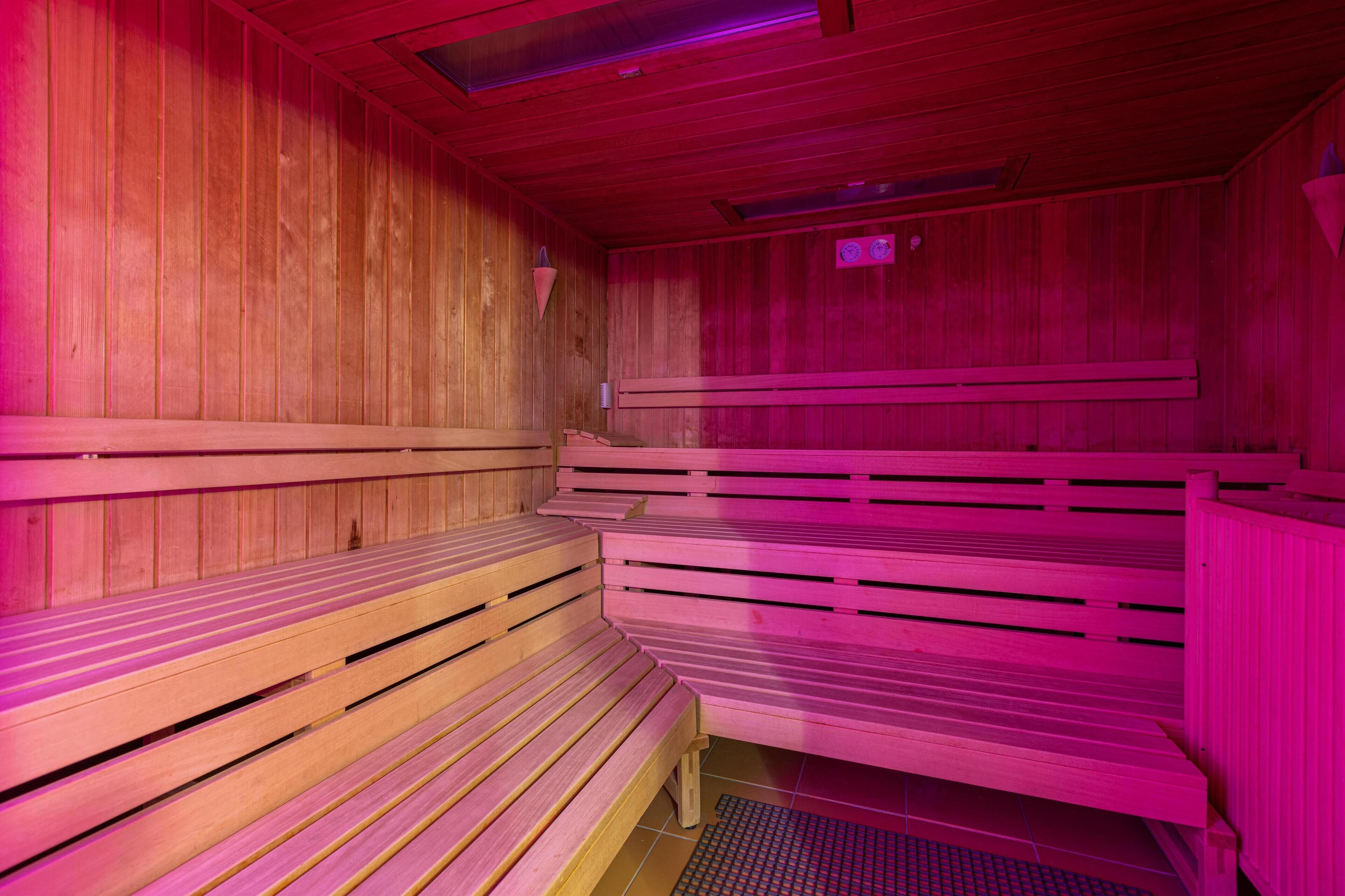 Un sauna avec des bancs en bois et un plafond en pente.