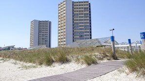 A coastal walkway leading to modern high-rise buildings with a clear sky. - IFA Fehmarn Hotel & Ferien-Centrum (Fehmarn)
