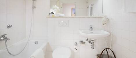 Un baño moderno con bañera, inodoro, lavamanos y ducha.