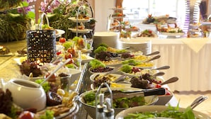 A buffet with various dishes and a candle centerpiece. - IFA Fehmarn Hotel & Ferien-Centrum (Fehmarn)