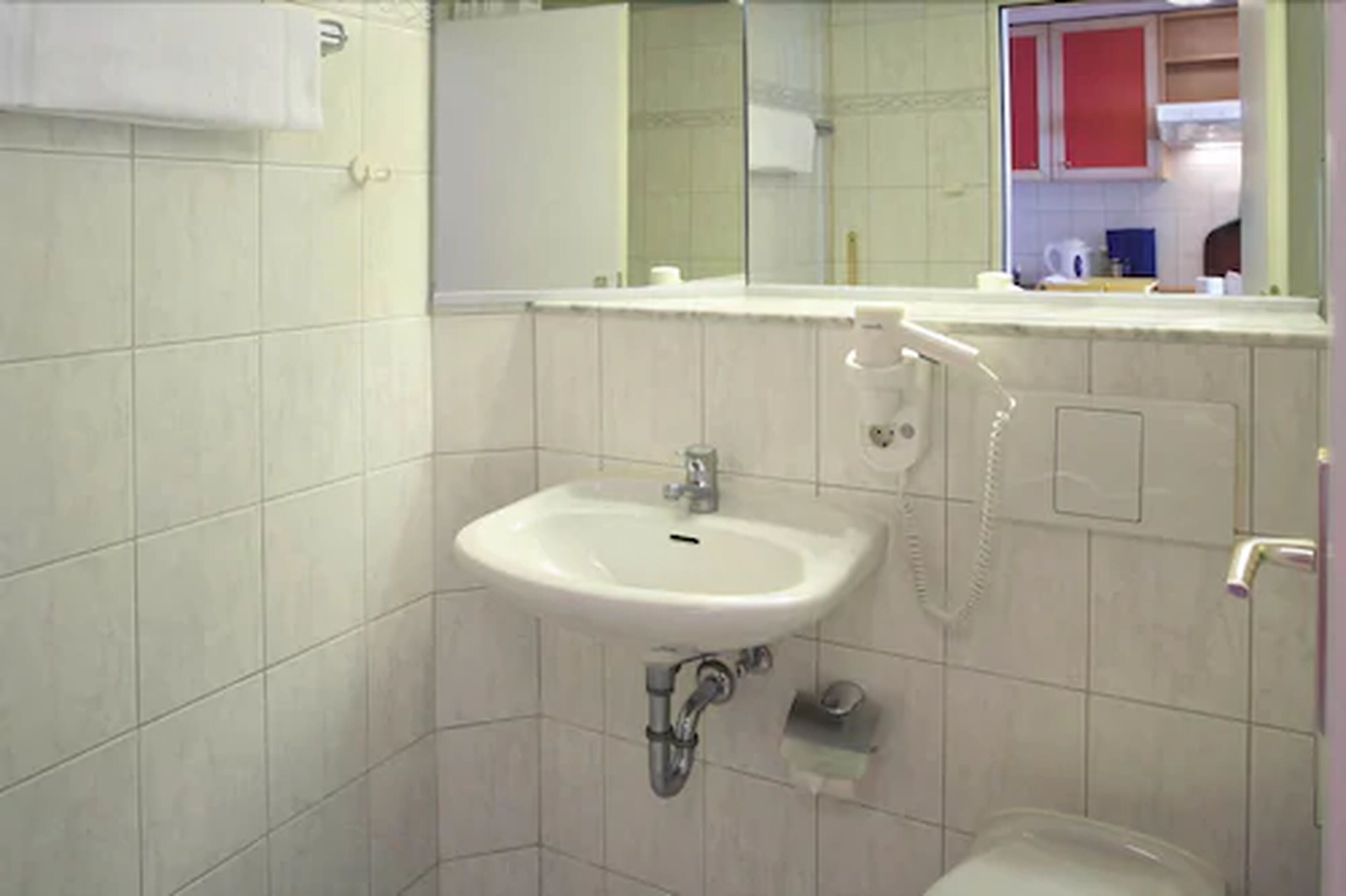 A bathroom with a sink, mirror, and toilet.