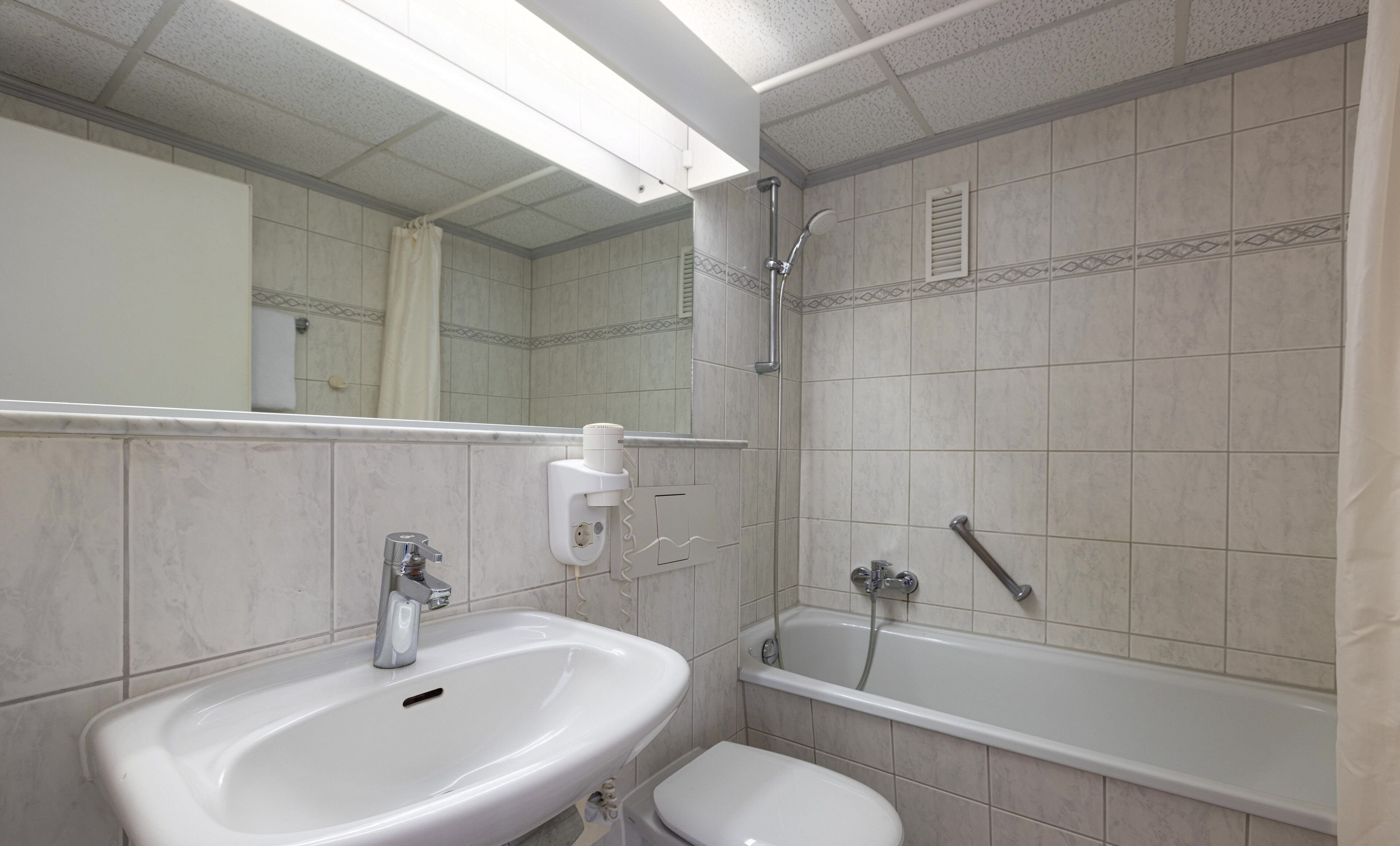 A bathroom with a sink, toilet, and bathtub.