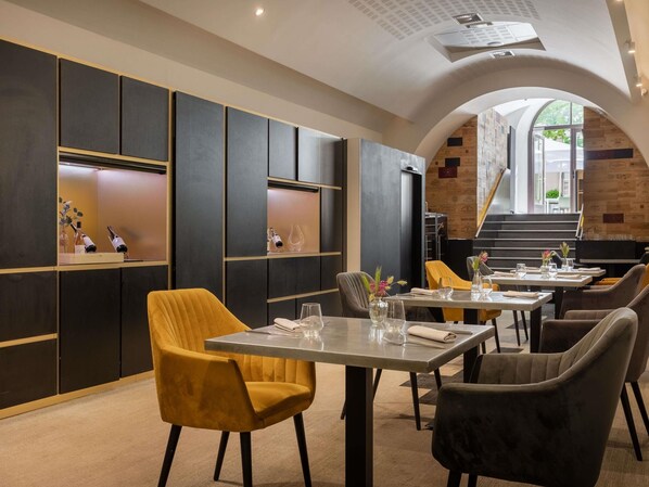 Un comedor moderno con mesas altas, sillas cómodas y vistas a la escalera exterior.