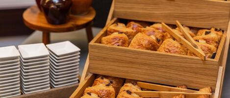 Cajas de madera llenas de pasteles y una pila de platos blancos.