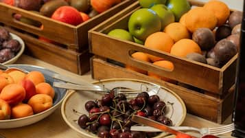 Wooden crates containing various fruits like apples, oranges, and plums.