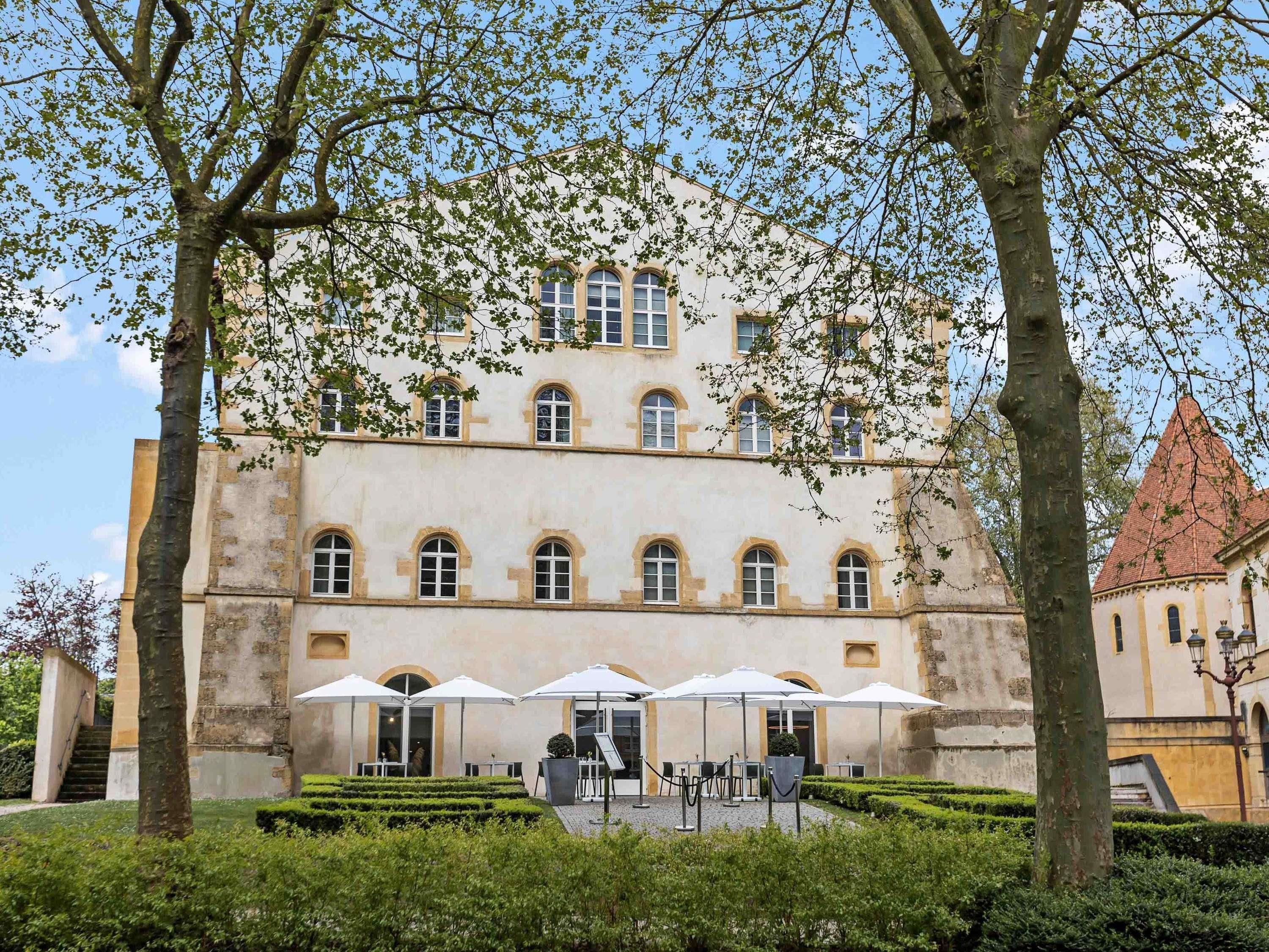 A historic building with a symmetrical facade, large windows, and a central entrance.
