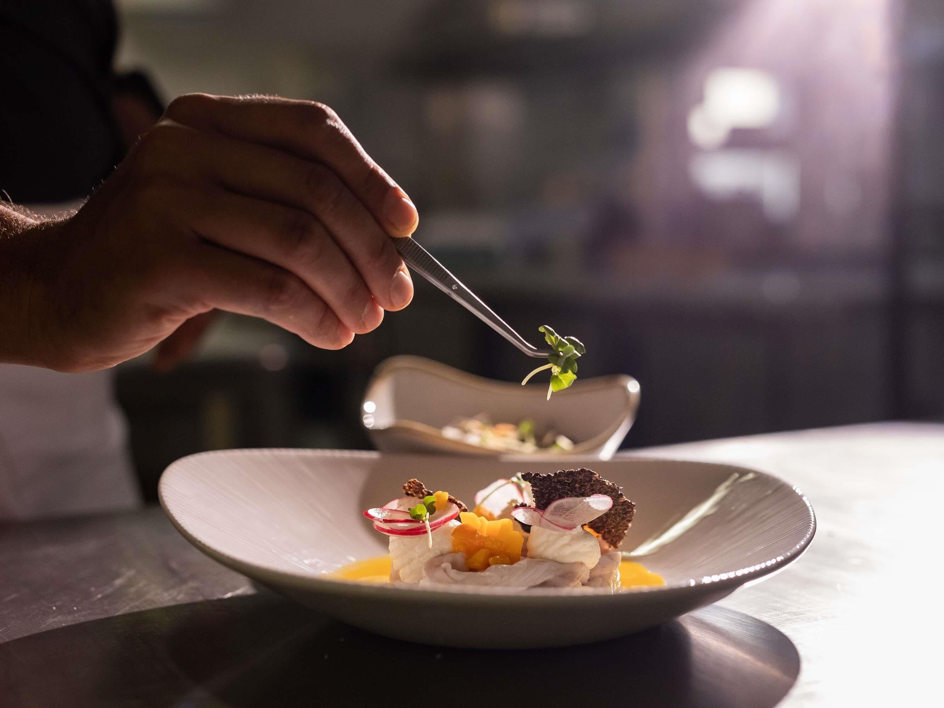 Una persona usa un tenedor para servir comida de un plato.