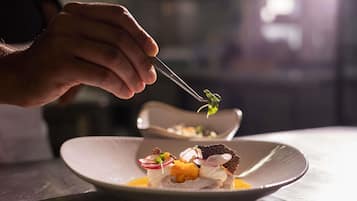 Una persona usa un tenedor para servir comida de un plato.