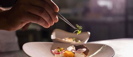 A person using a fork to pick up food from a plate.