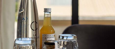 A table with various glass bottles and a glass pitcher, likely containing beverages.