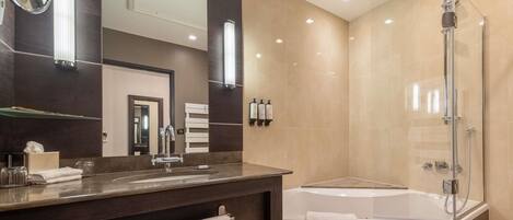 A modern bathroom with a large mirror, a bathtub, and a shower.
