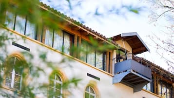 Un bâtiment doté de nombreuses fenêtres en arc de cercle et d’un balcon.