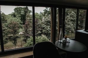 A room with large windows offering a view of a forested area. - La Citadelle Hotel Metz - MGallery Collection (Metz)