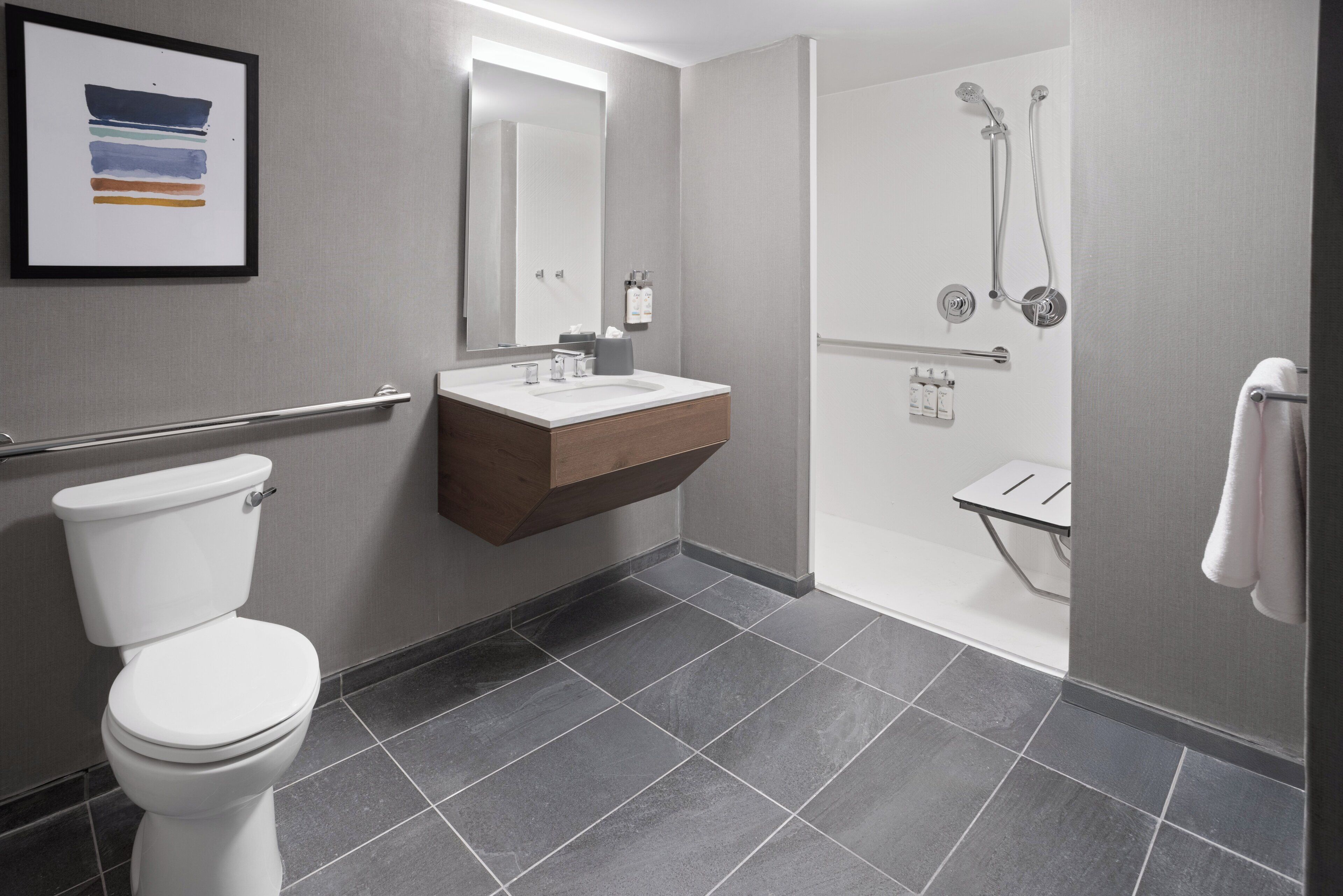 Un baño moderno con inodoro, lavamanos y ducha.