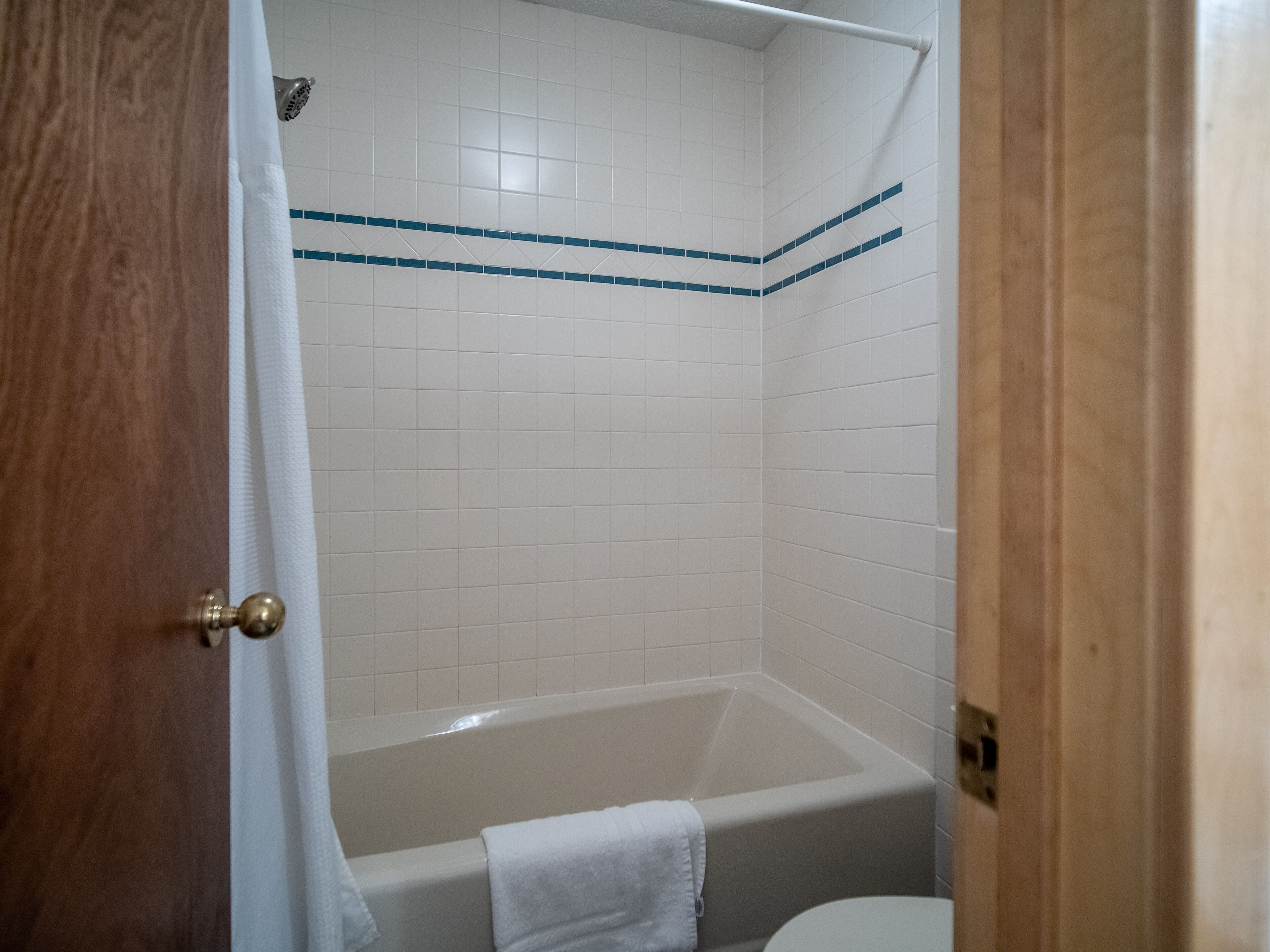 Ein Badezimmer mit Badewanne, Toilette und Duschbereich.
