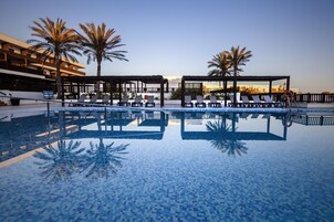 Una piscina al aire libre, sillones reclinables de piscina