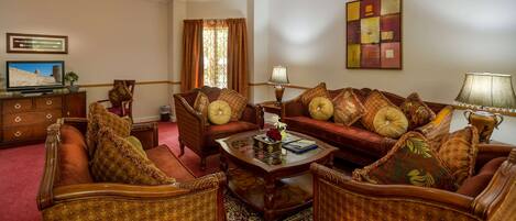 A traditional living room with a sofa set, a coffee table, and a television on a wooden cabinet.