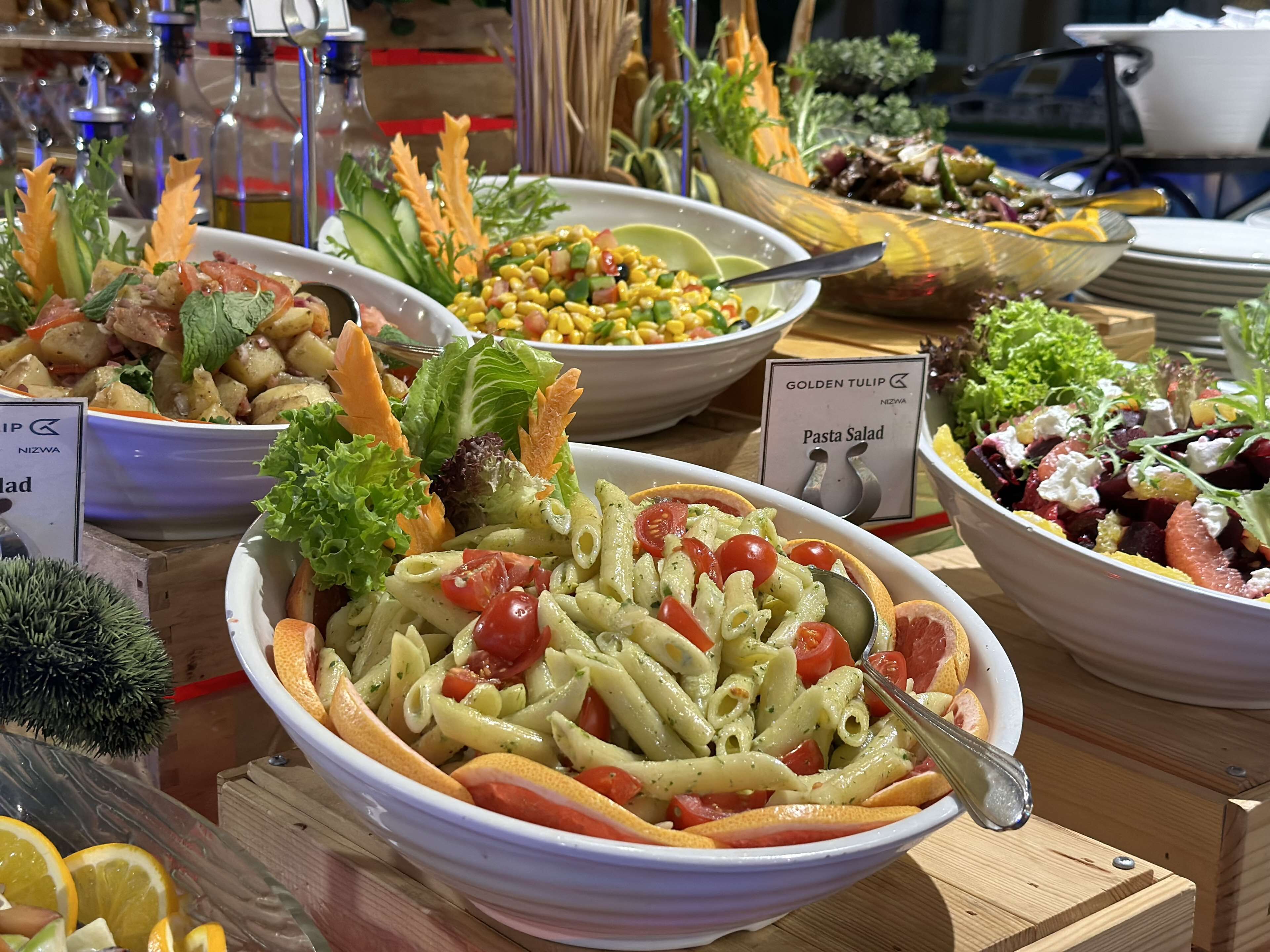 Diversos plats de pasta i amanides presentats en un bufet.