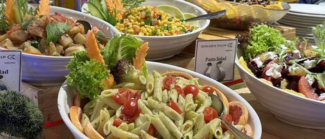 Una variedad de platos de pasta y ensaladas en una mesa tipo bufé.