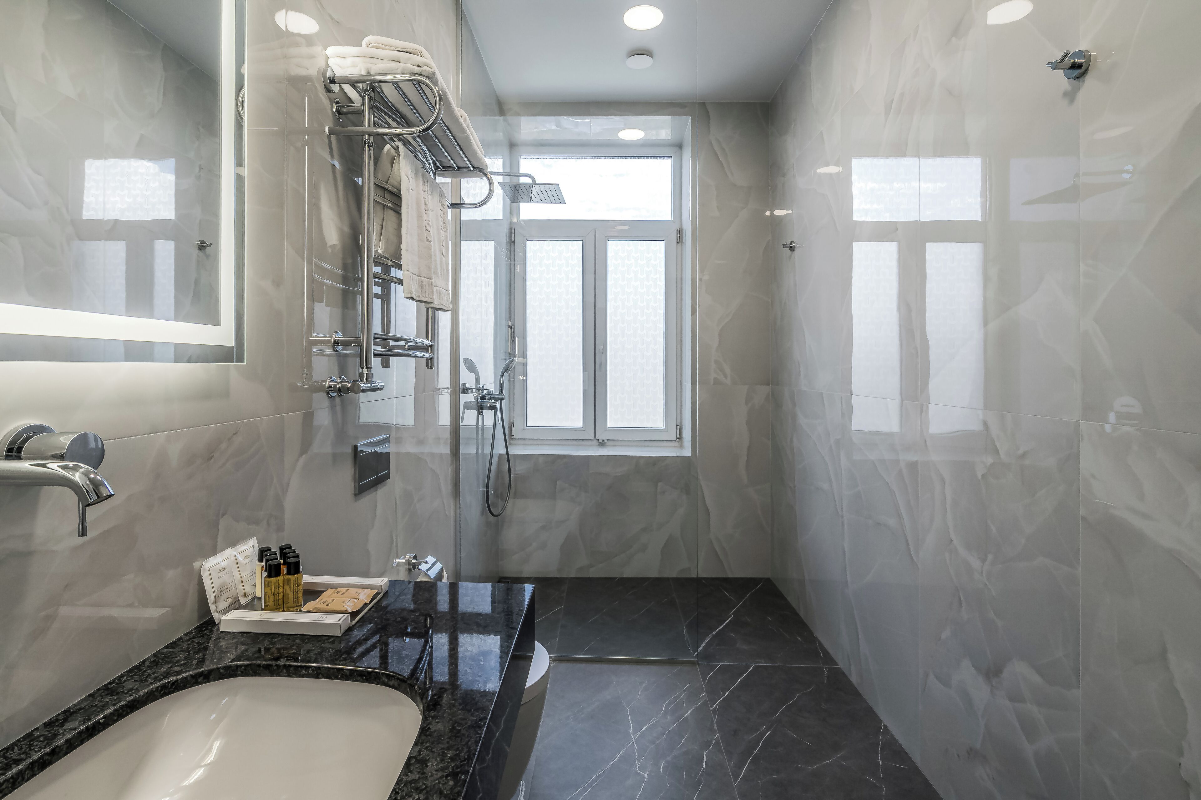 A modern bathroom with a large mirror, a bathtub, and a shower.