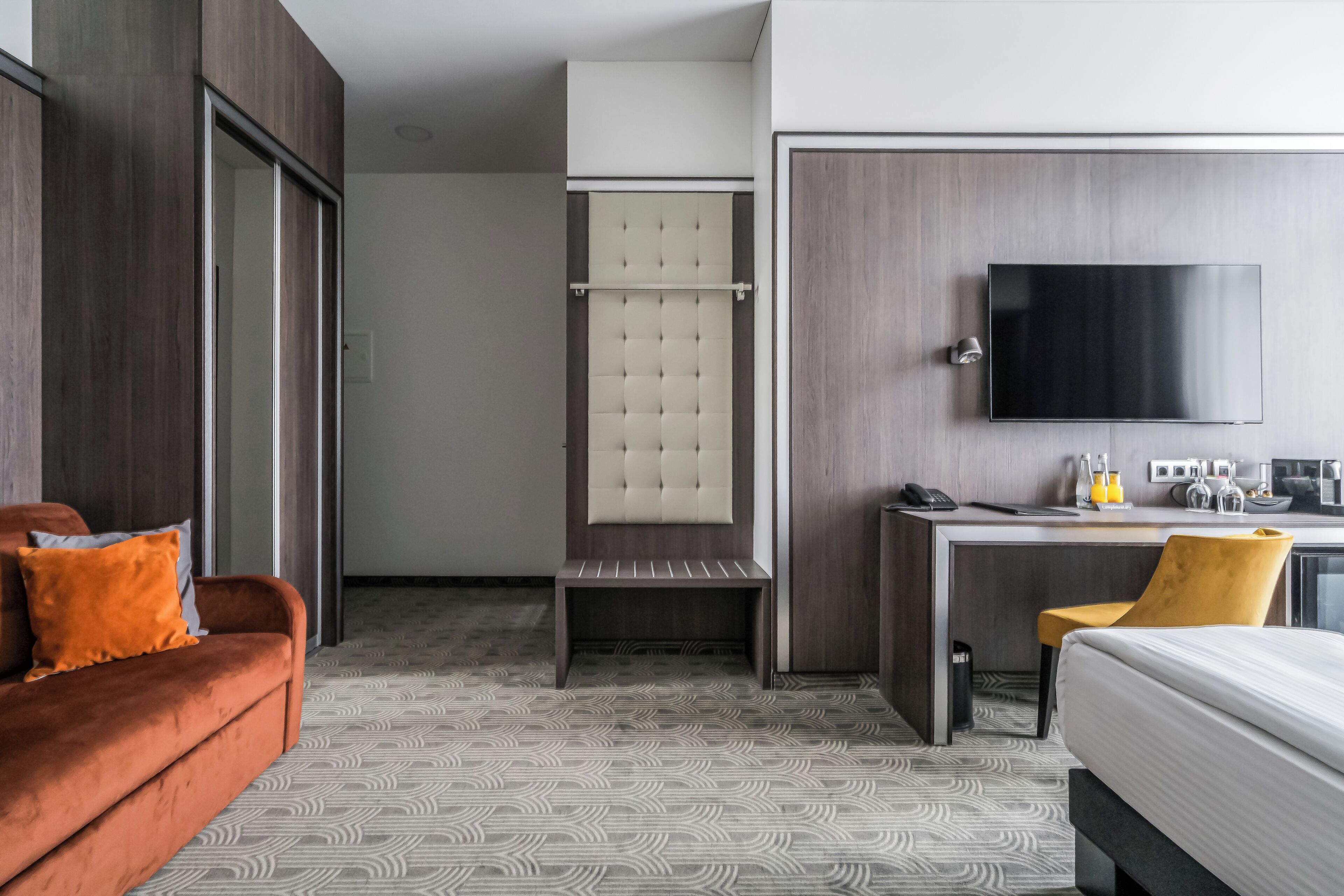 Une chambre d’hôtel équipée d’un lit, d’un bureau, d’une chaise, d’une télévision et d’une armoire.