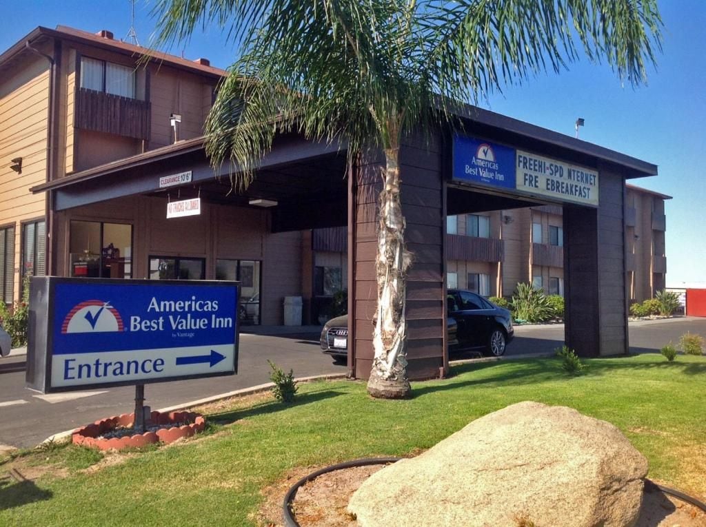 Señal de entrada para Americas Best Value Inn, un edificio con un cartel claro que indica la dirección de entrada.