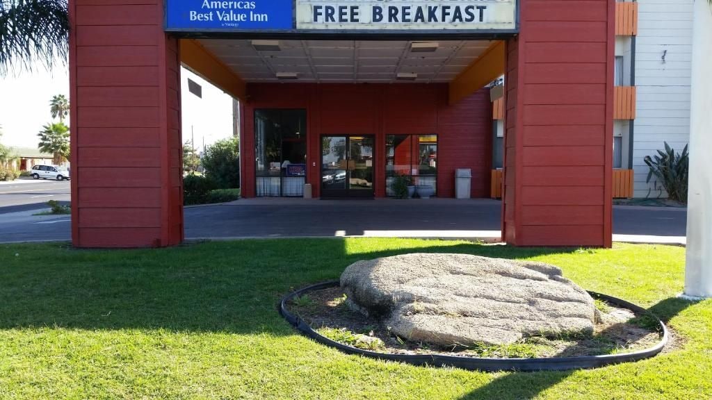 Un edificio con fachada roja y un letrero que indica 'FREE BREAKFAST'.