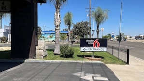 A sign for 'studio 6 suites' with an entrance arrow. - Studio 6 Suites Delano, CA (Delano)