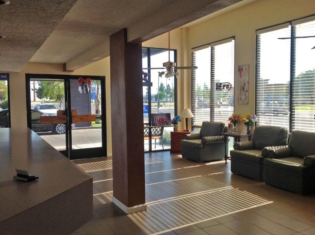 A reception area with a counter, seating, and large windows.