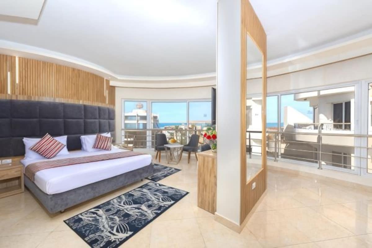 Une chambre d’hôtel moderne dotée d’un grand lit, d’un balcon avec vue et d’un coin repas.