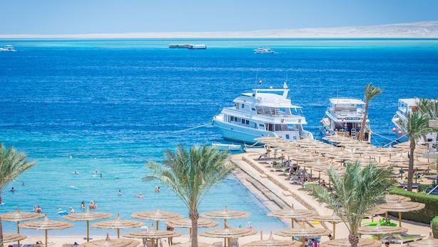 A coastal resort with a pool area, beach umbrellas, and boats in the background. - Seagull Beach Resort Families & Couples Only - All Inclusive (Hurghada)
