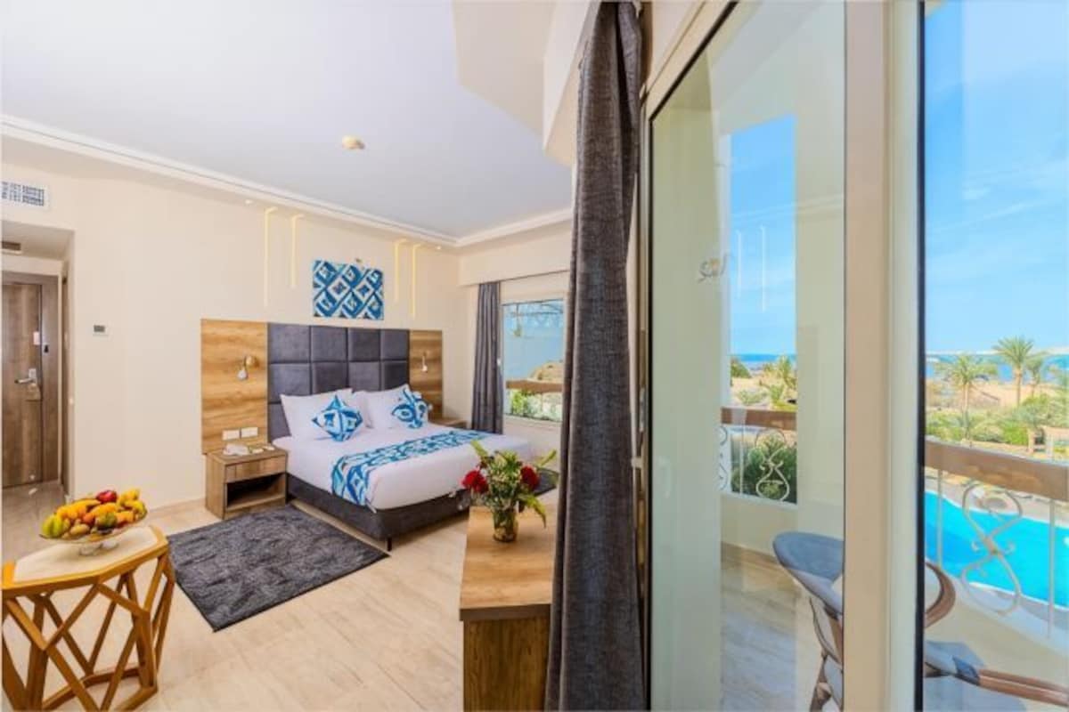 Une chambre avec un lit, une table de chevet et une vue sur une piscine.