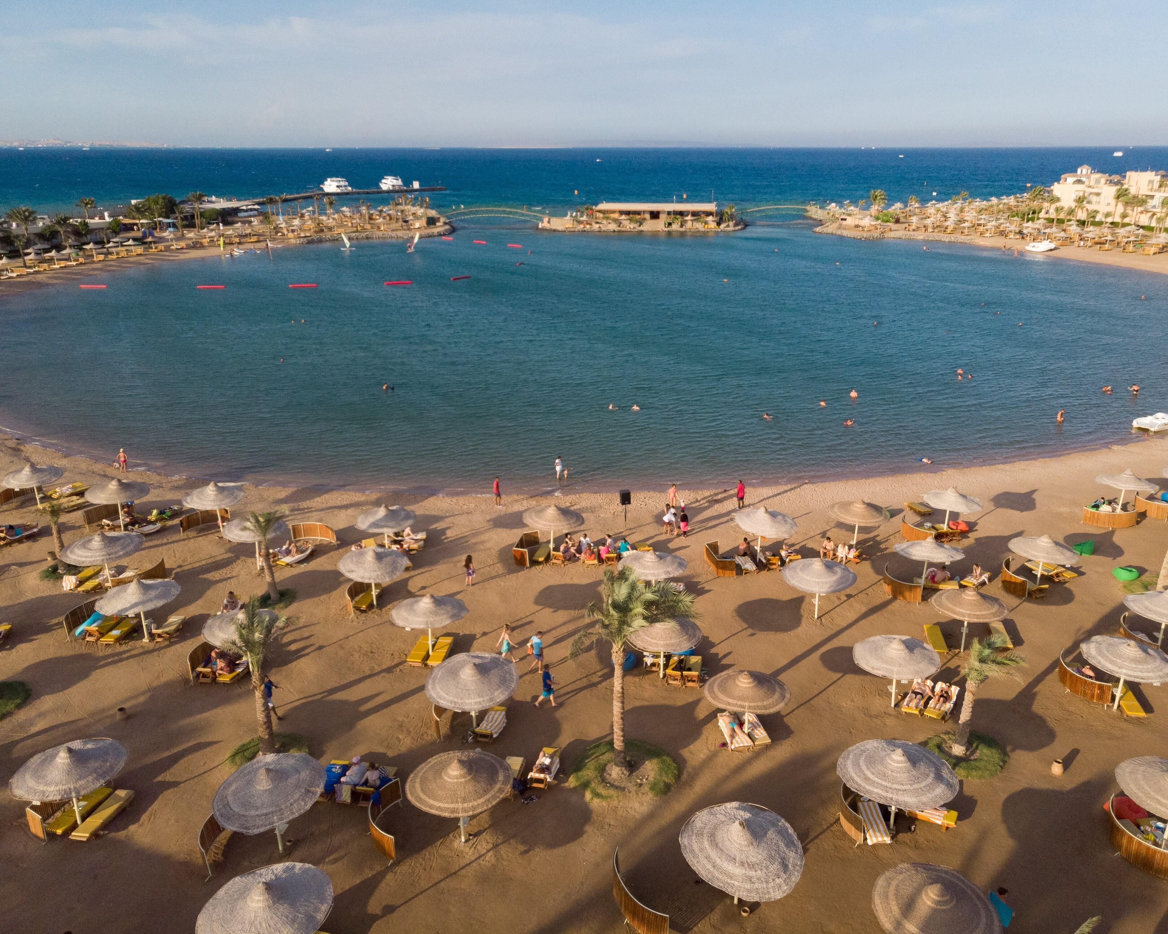 Een privéstrand, ligstoelen aan het strand, parasols, strandlakens