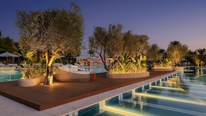 A poolside area with lounge chairs, planters, and a wooden deck. - Desert Rose  (Hurghada)