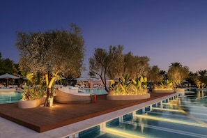 A poolside area with lounge chairs, planters, and a wooden deck.